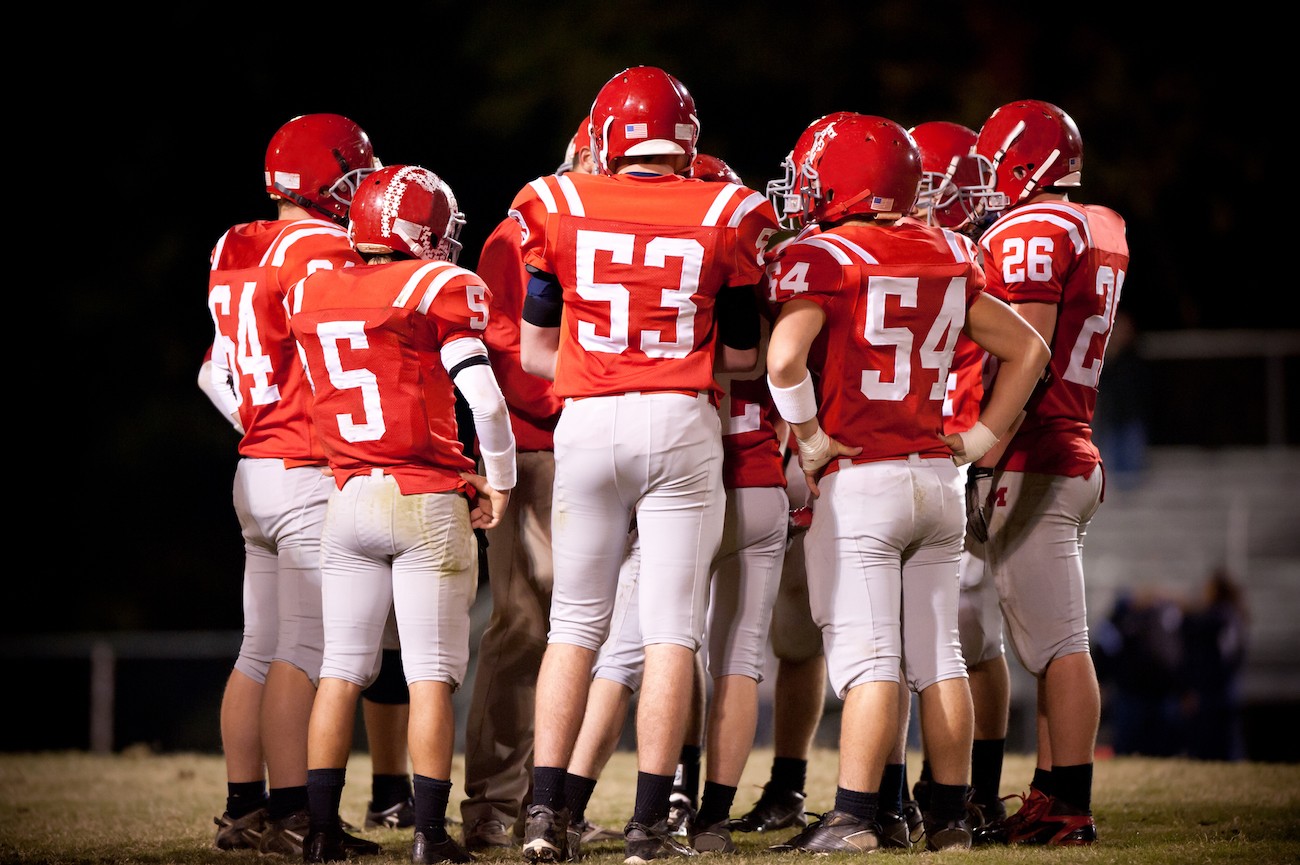 A group of football players in a huddle